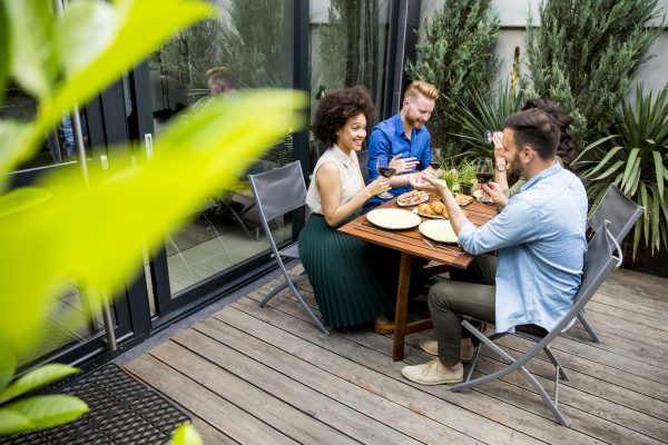 Young people enjoy the food and drink and have great fun outdoors in backyard